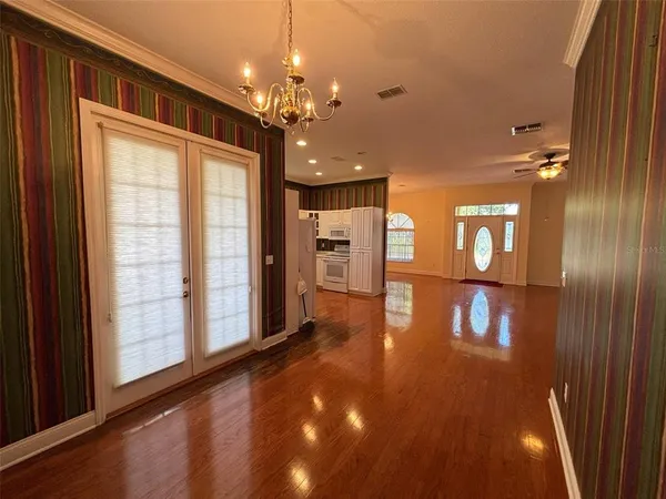 a view of a hallway with couches and chandelier