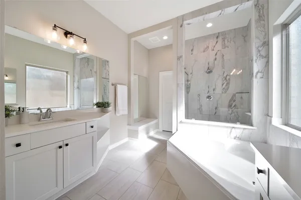 a spacious bathroom with a shower a sink and a large mirror