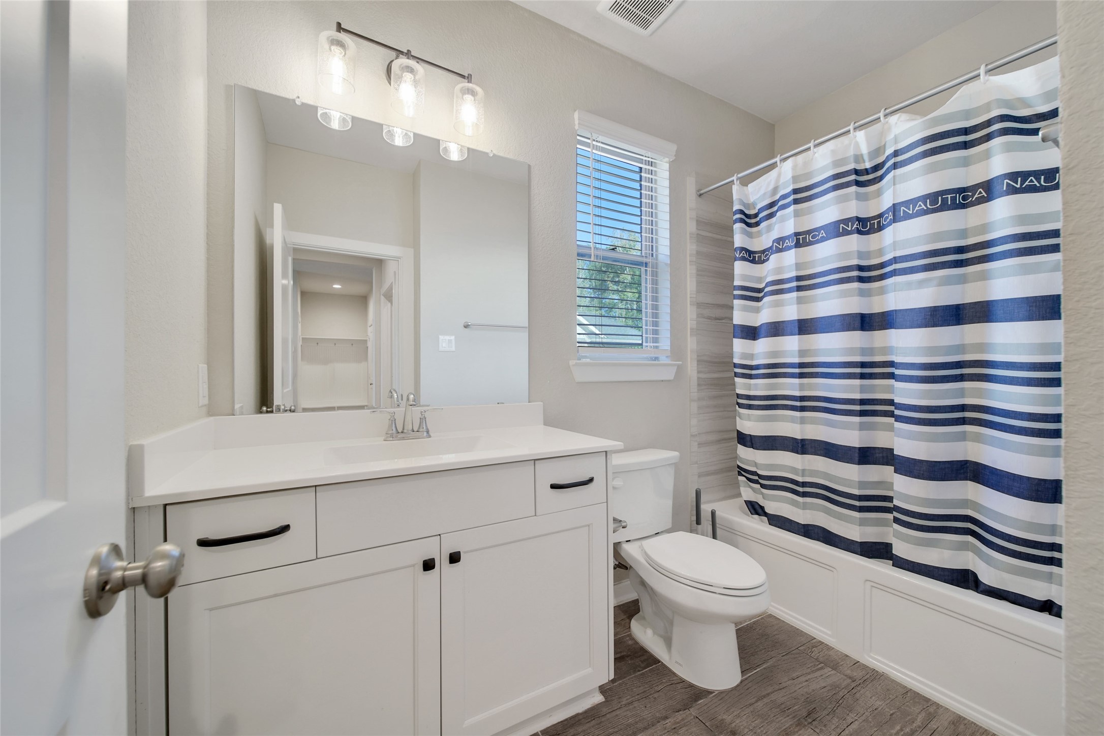 128 Yellow Perch Way Willis, TX 77318 - Photo 24 of 32 a bathroom with a sink a toilet a mirror and shower curtain