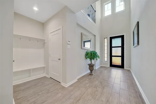 a view of a hallway with wooden floor and a potted plant