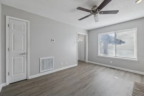 an empty room with a ceiling fan and window