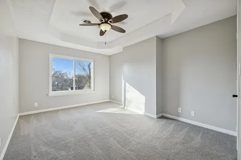a view of an empty room and a ceiling fan