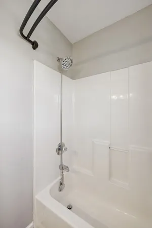 a white bath tub sitting next to a white sink and a shower