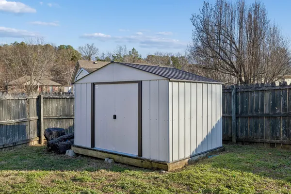 a view of a backyard with barn and wooden fence