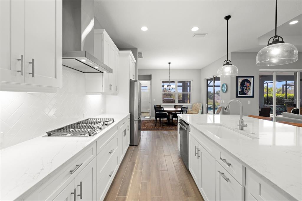 14375 Skipping Stone Loop Parrish, FL 34219 - Photo 17 of 87 a large kitchen with kitchen island a large counter space a sink stainless steel appliances and cabinets