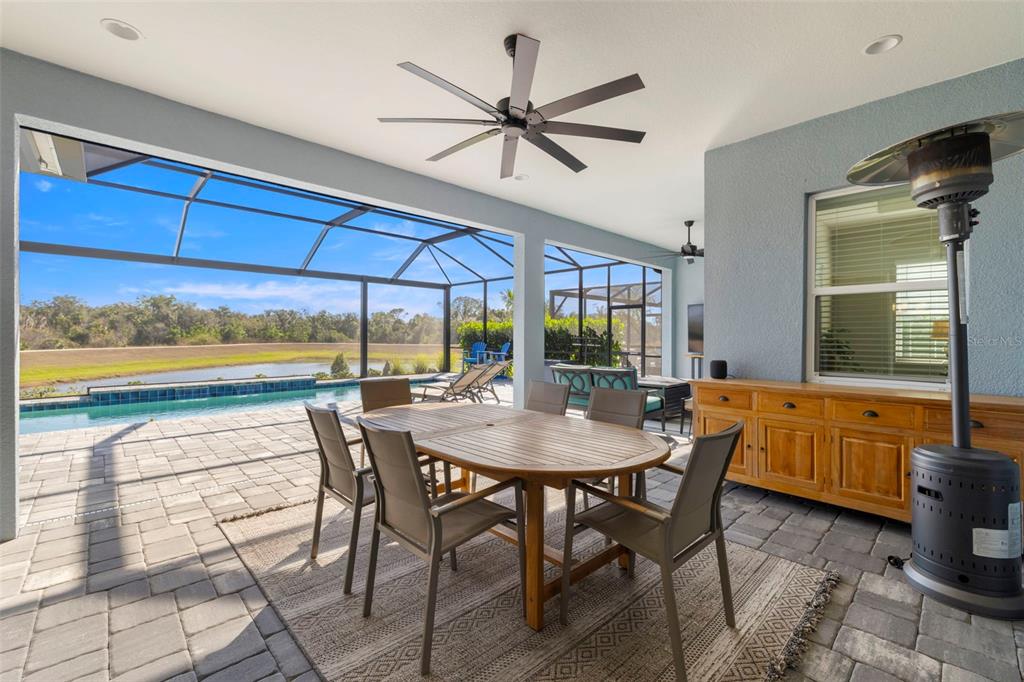14375 Skipping Stone Loop Parrish, FL 34219 - Photo 45 of 87 a dining room with furniture a floor to ceiling window and a ceiling fan
