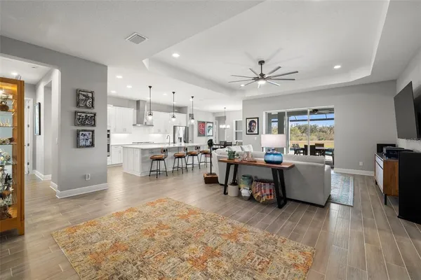 a large kitchen with stainless steel appliances kitchen island granite countertop a table chairs and a refrigerator