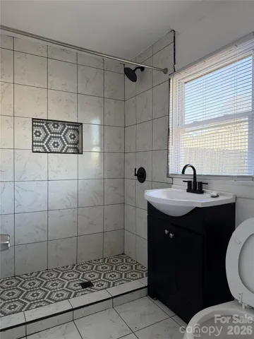 a bathroom with a sink shower and a mirror