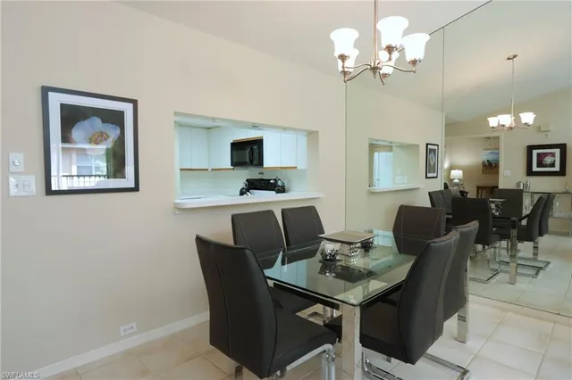 a view of a dining room with furniture and a chandelier fan