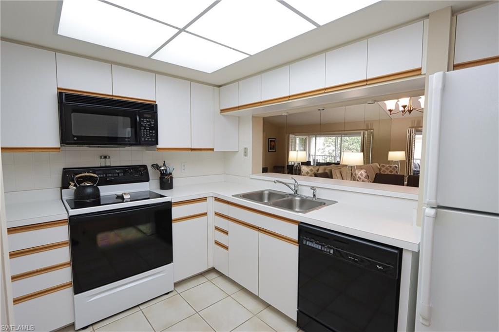 5637 Turtle Bay Drive, Unit II22 Naples, FL 34108 - Photo 6 of 20 a kitchen with a sink stove and microwave