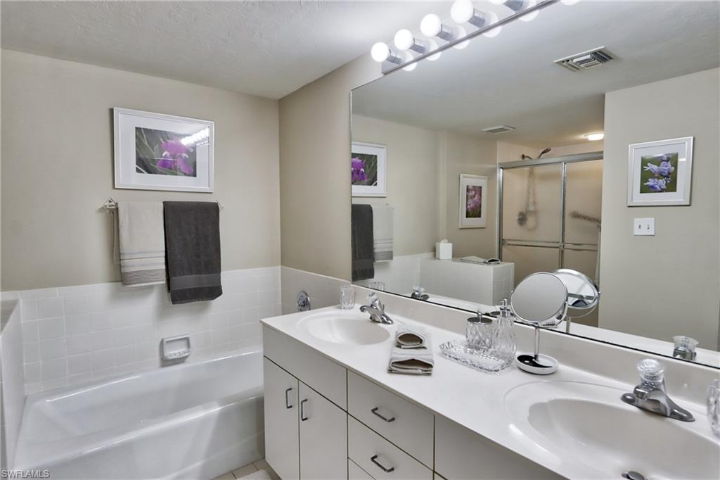 5637 Turtle Bay Drive, Unit II22 Naples, FL 34108 - Photo 9 of 20 a bathroom with a tub sink and mirror