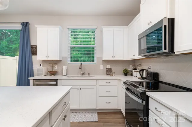 a kitchen with a sink stove and microwave