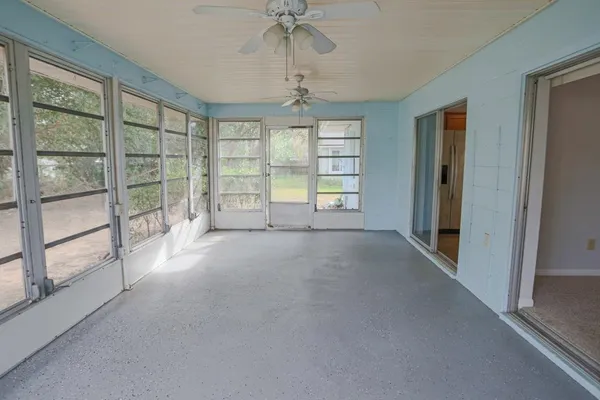 an empty room with windows and chandelier