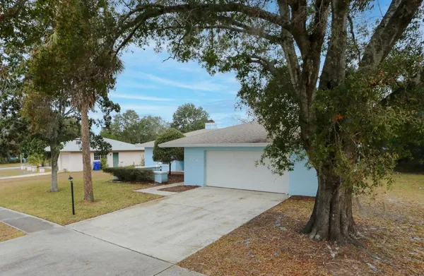 a front view of a house with a yard and trees