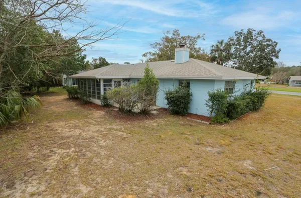 a view of a house with a yard and potted plants