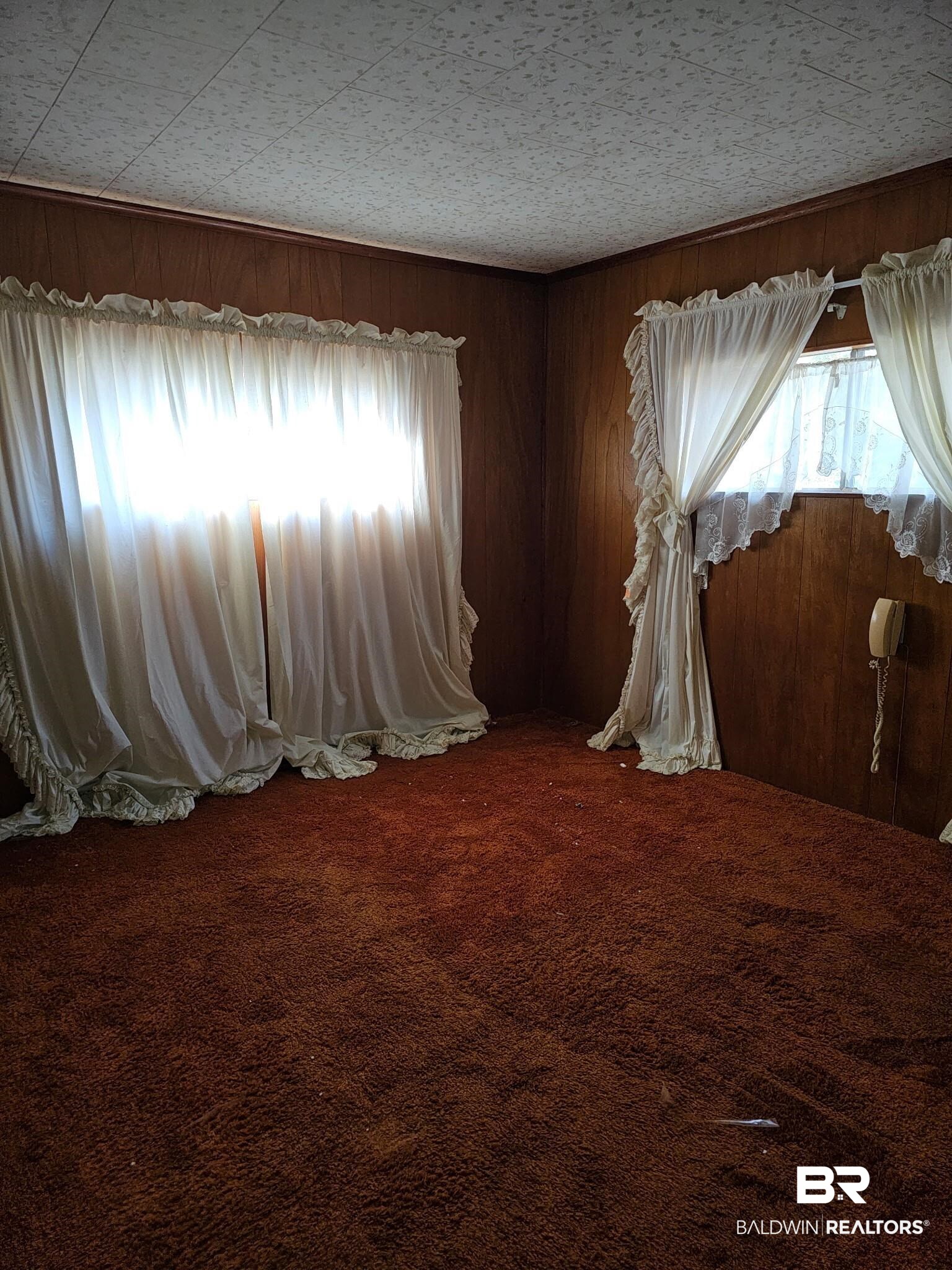 304 Sutherland Drive Mobile, AL 36611 - Photo 9 of 18 Interior space with carpet and wooden walls