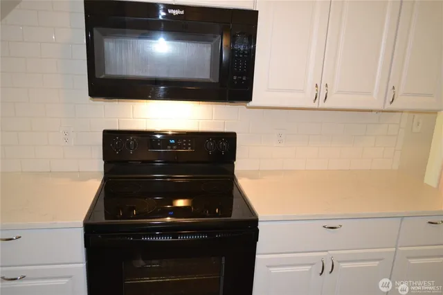 a view of microwave and cabinets