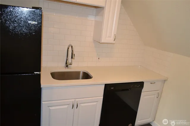 a close view of a sink and dishwasher with kitchen island