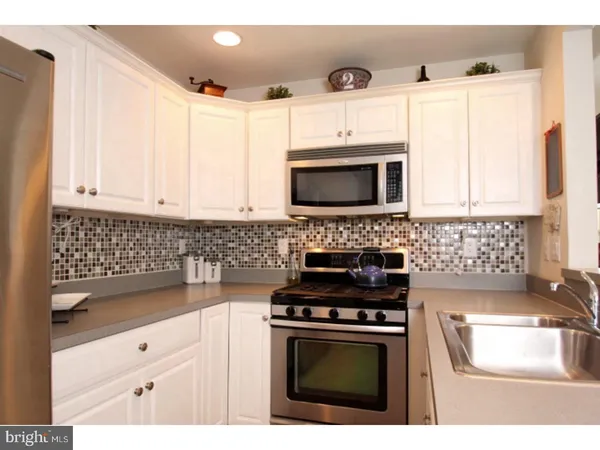 a kitchen with granite countertop a stove top oven microwave and cabinets