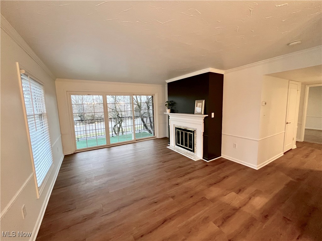 22701 Center Ridge Road, Unit 201 Rocky River, OH 44116 - Photo 16 of 37 Unfurnished living room with crown molding and dark hardwood / wood-style floors