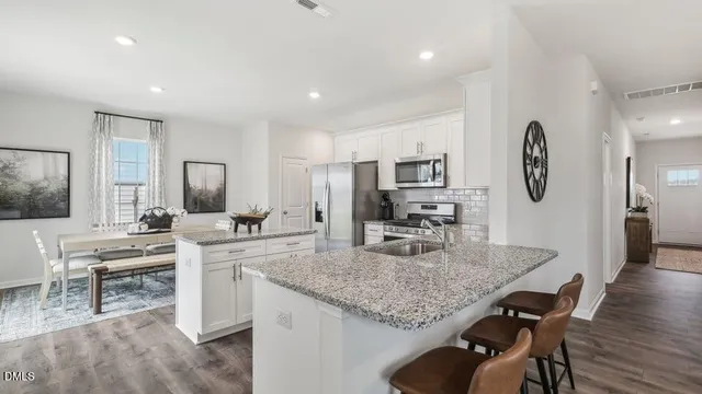 a kitchen with a table chairs refrigerator and cabinets