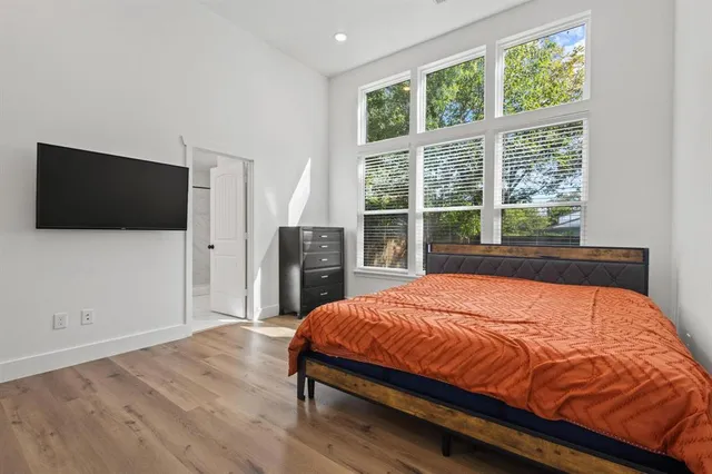 a bed sitting in a spacious bedroom next to a window