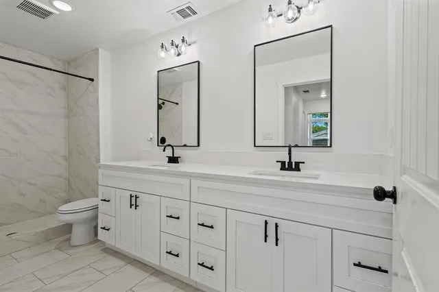 a bathroom with double sink and a mirror