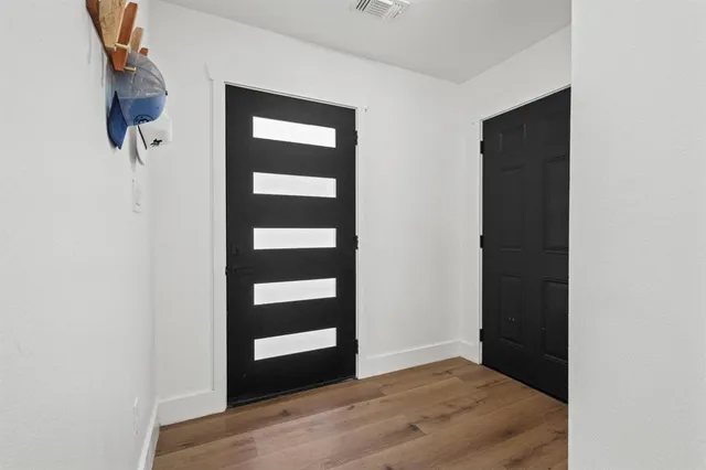 a view of an empty room with wooden floor