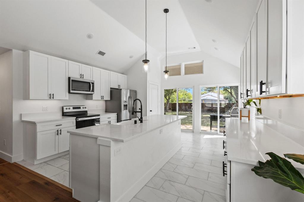 511 Maple Street Howe, TX 75459 - Photo 10 of 38 a kitchen with stainless steel appliances a stove a sink a microwave a dining table and chairs