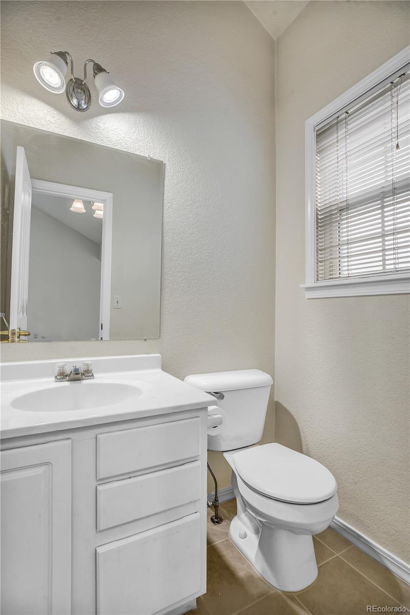 11690 West 46th Avenue Wheat Ridge, CO 80033 - Photo 22 of 33 a bathroom with a toilet a sink and mirror