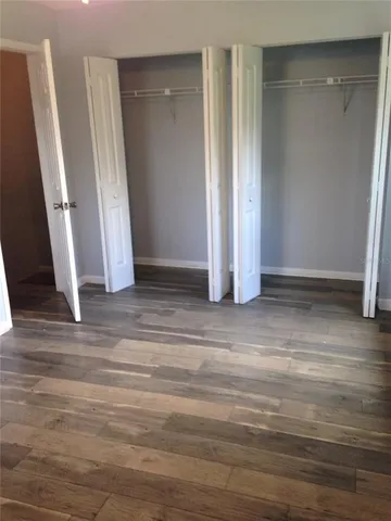 an empty room with wooden floor and entrance