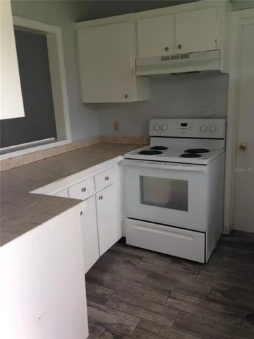 a kitchen with granite countertop white cabinets and white appliances