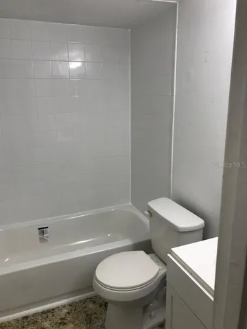 a white toilet sitting next to a bath tub