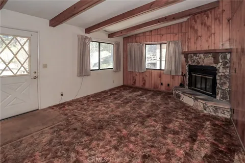 an empty room with windows and fireplace