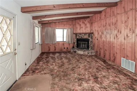 a view of an empty room with a fireplace and a window