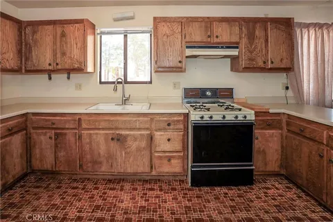 a kitchen with stainless steel appliances a stove a sink and a microwave