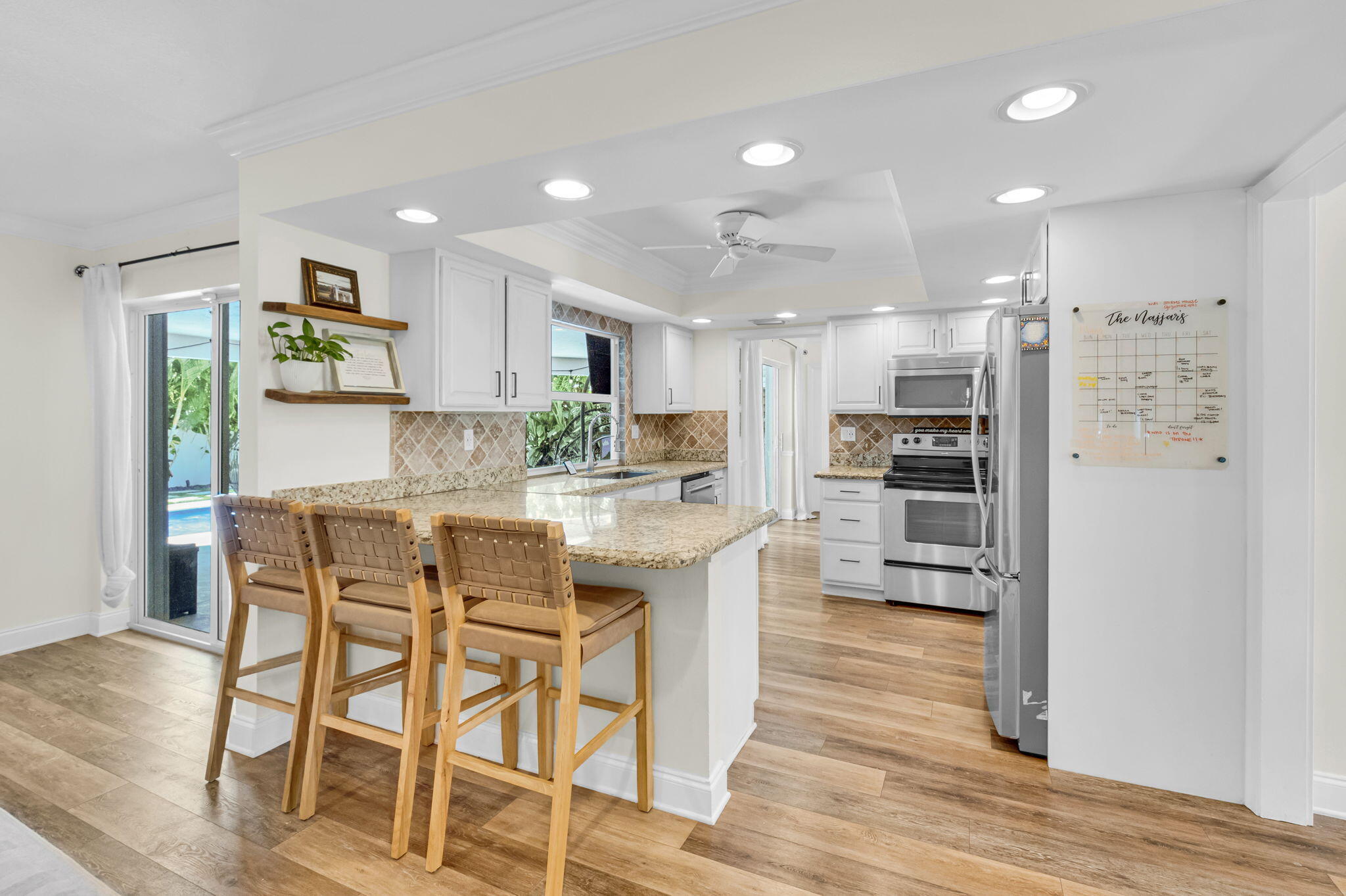 769 Berkley Street Boca Raton, FL 33487 - Photo 6 of 106 a kitchen with stainless steel appliances kitchen island granite countertop a refrigerator and a stove top oven