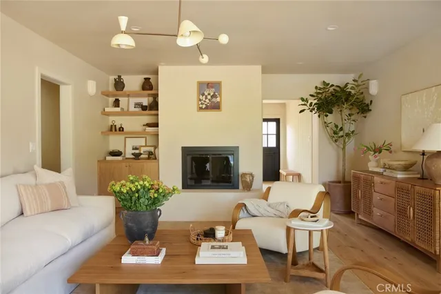 a living room with furniture a chandelier and a fireplace