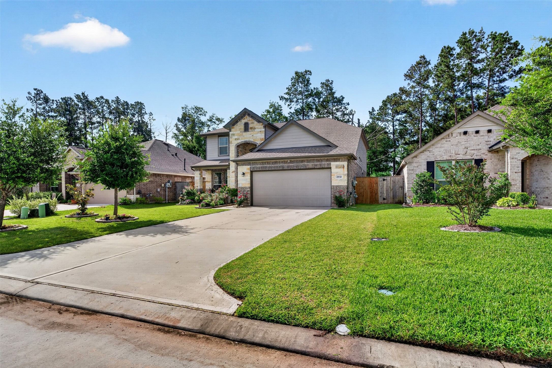 2832 Mistygate Court Conroe, TX 77301 - Photo 43 of 50 Front exterior angle highlighting the driveway, mature trees, and curb appeal.
