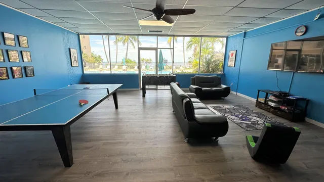 a living room with furniture a desk and a flat screen tv