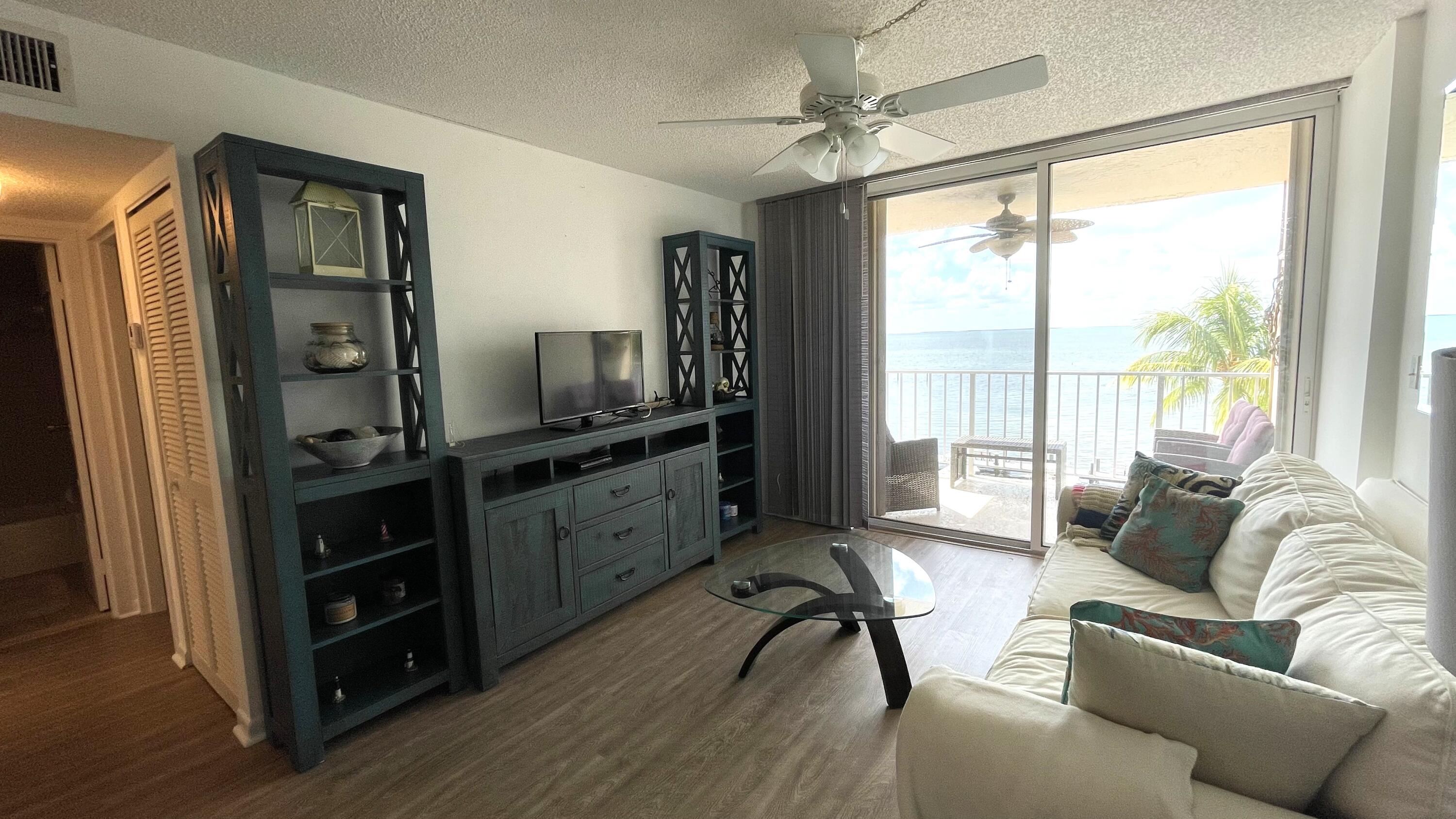 88500 Overseas Highway, Unit 413 Islamorada, FL 33036 - Photo 5 of 25 a living room with furniture and a flat screen tv