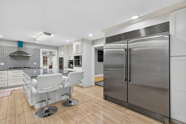 a kitchen with a refrigerator and white cabinets