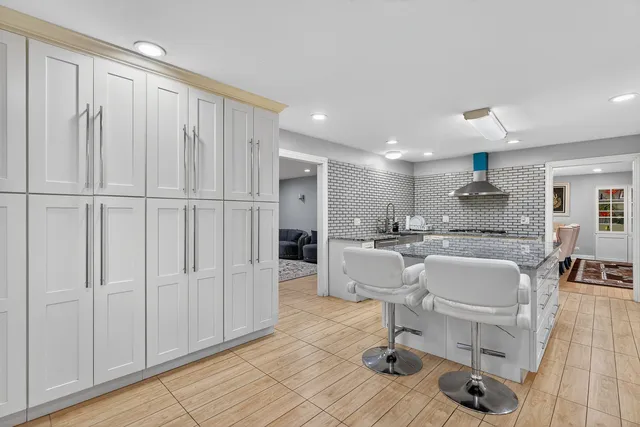 a large white kitchen with a white table and chairs