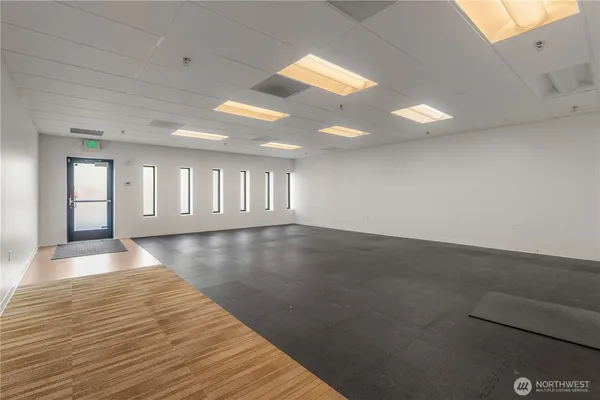 a view of an empty room with window and wooden floor