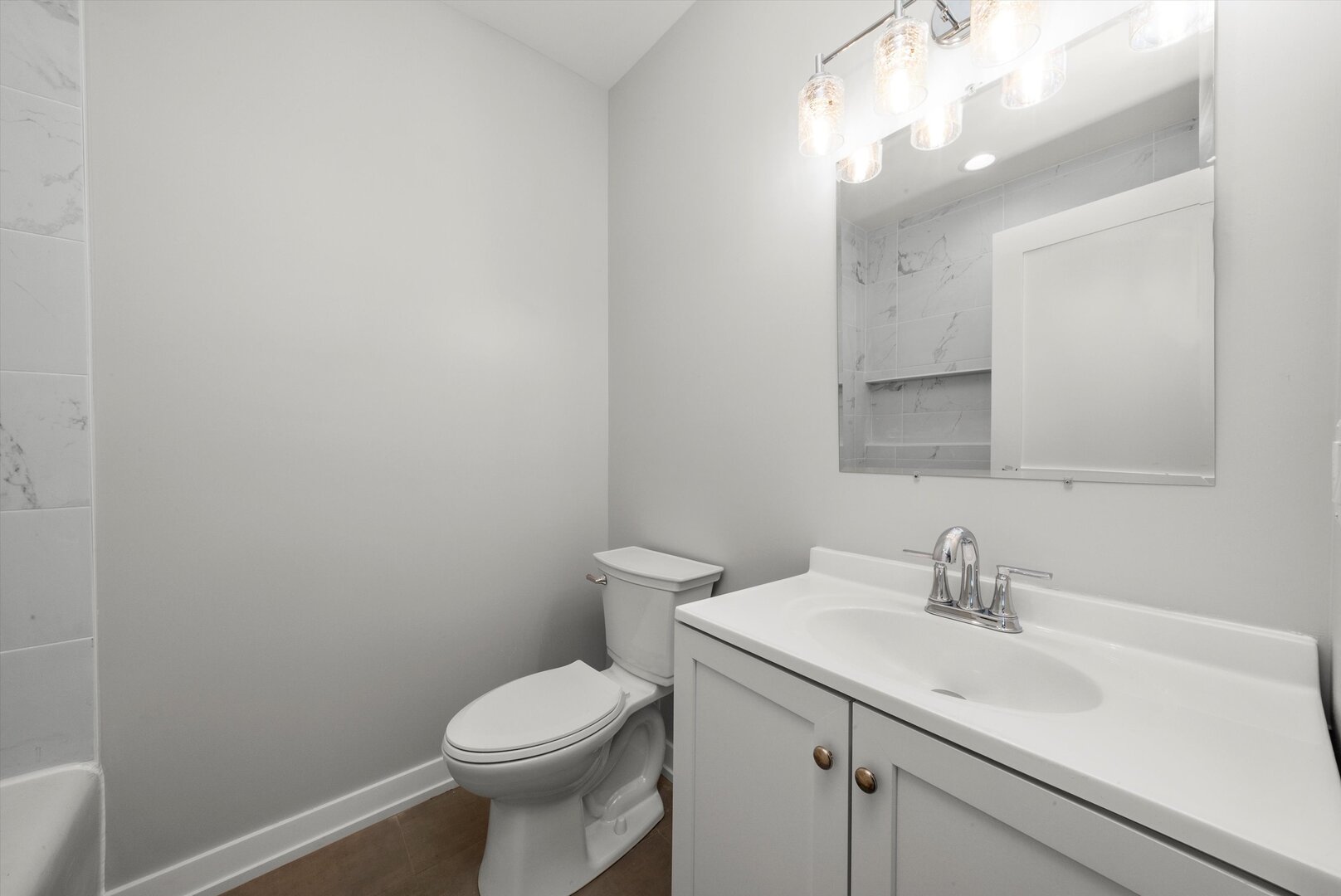 5738 South Archer Avenue Chicago, IL 60638 - Photo 6 of 16 a bathroom with a sink a toilet and a mirror