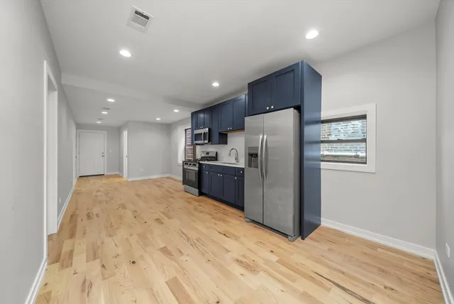 a kitchen with stainless steel appliances granite countertop a refrigerator and a stove