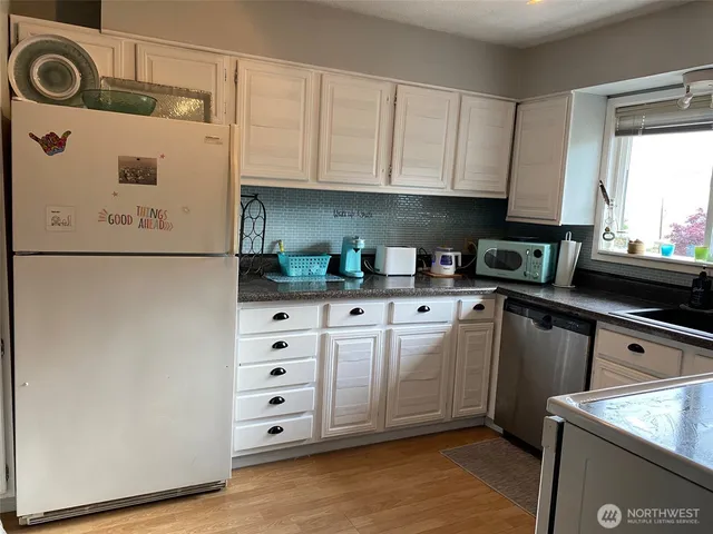 a kitchen with cabinets appliances and a sink
