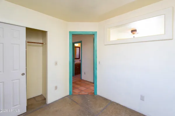 an empty room with a window and a fan