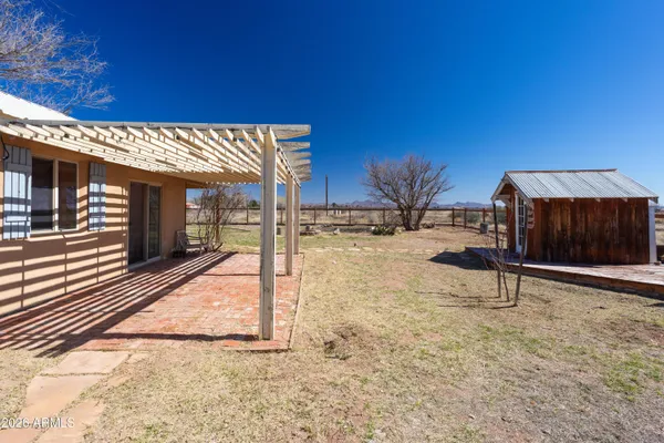 a view of a backyard with wooden fence and a bench
