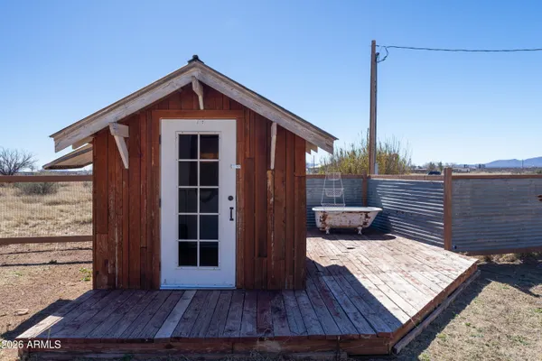 a view of a patio with table and chairs under an umbrella with wooden fence